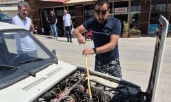 Otomobilin motoruna giren yılanı sopayla çıkardı