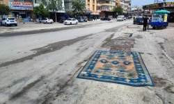 Mahalleli, onarılmayan yollara tozdan korunmak için halı serdi