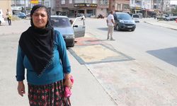 Adana'da tozdan rahatsız olan kadın yoldaki çukurları halıyla kapattı