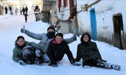 Mahalle yolunu kızak pistine çeviren çocuklar karın tadını çıkardı