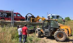 Köprüden düşen traktörün altında kalan sürücü iş makinesiyle kurtarıldı