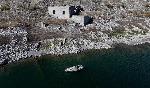 Su altında kalan mahallesinin üzerinde balık avlıyor