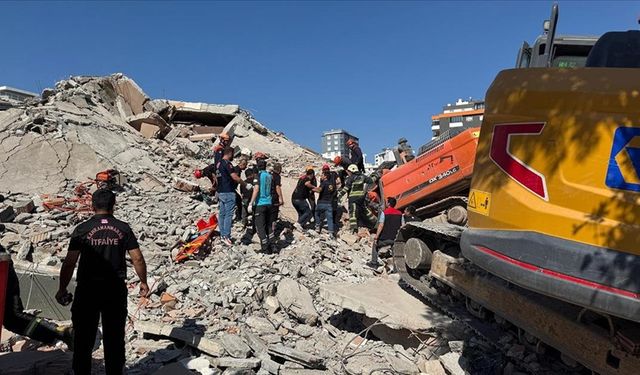 Kahramanmaraş'ta ağır hasarlı bina yıkılırken iş makinesinin üzerine devrildi