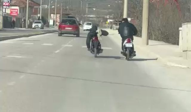 Kasksız sürücünün motosikleti yüzüstü yatarak kullandı