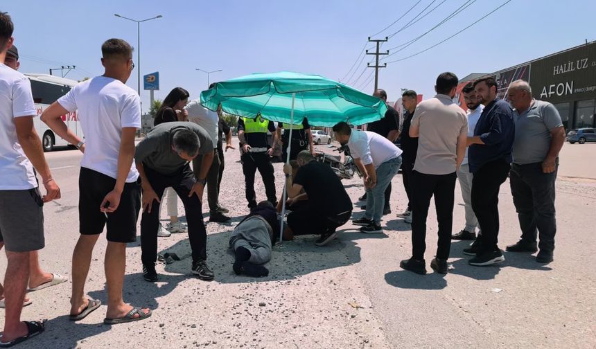 Yerdeki yaralı sürücüyü, ambulans gelene kadar plaj şemsiyesiyle güneşten korudular