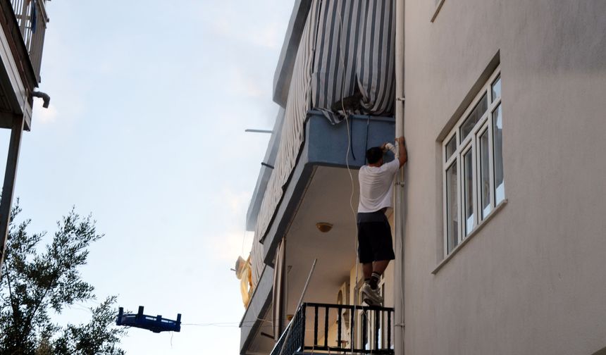Evde çıkan yangında mahsur kalan kediyi balkona tırmanıp kurtardı